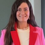 Silhouette of a person meditating in lotus pose against teal background.