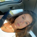 Silhouette of a person meditating in lotus pose against teal background.